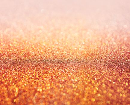 Red abstract background with shiny glitter. Pink festive sparkling macro texture. Holiday backdrop with copy space.