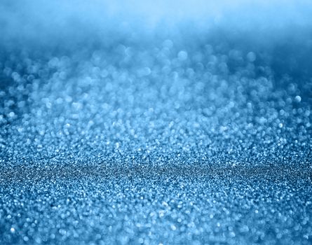 Classic blue abstract background with shiny glitter. Blue festive sparkling macro texture. Holiday backdrop with copy space.