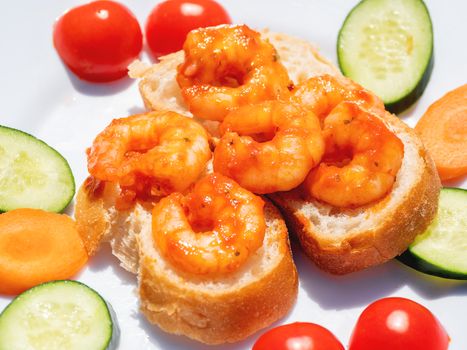 Mediterranean cuisine - freshly cooked shrimps on bread with vegetables. Seafood with cucumbers and tomatoes.