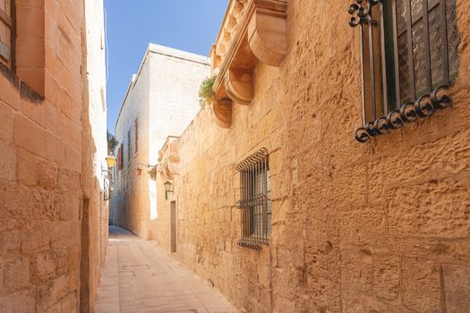 Narrow streets of Mdina, old capital of Malta. Stone buildings with old fashioned doors and balconies.