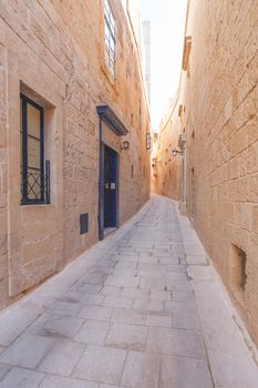 Narrow streets of Mdina, old capital of Malta. Stone buildings with old fashioned doors and balconies.
