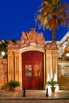 Illuminated streets of Mdina, ancient capital of Malta. Night view on buildings and wall decorations into ancient town.