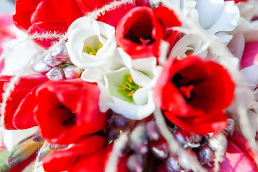 Bridal bouquet on sunlight. Traditional floral composition with bright red tulips.