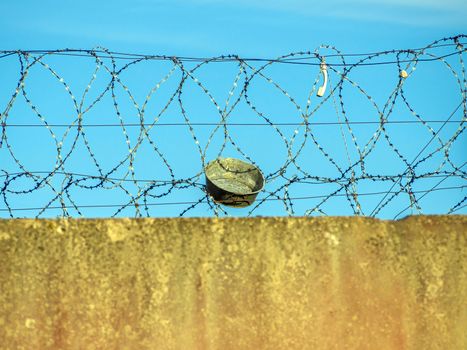 Restricted Area Barbed Fence. Concrete wall, against the backdrop of barbed wire, the concept of prison, salvation, Refugee, lonely, space for text. Protected object, no unauthorized entry.