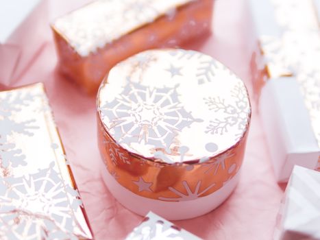 Valentine's Day presents with golden snowflakes. Gift boxes on pink crumpled paper background.