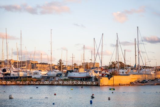 Dock with yachts on Marsamxett harbour. Many sailing ships lie alongside. Valletta, Malta.