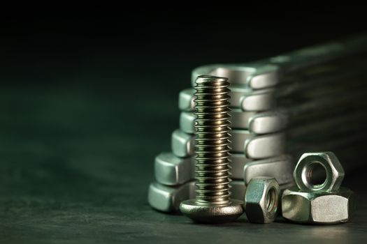 Bolt nuts and wrench on cement floor in darkness. Closeup and copy space for text. Concept of mechanical engineering jobs.