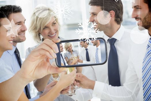 Hand holding smartphone showing photo against hanging decorations