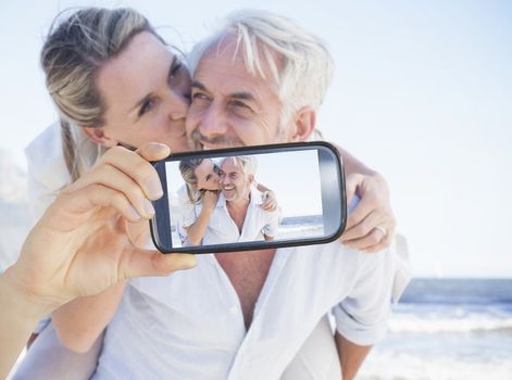 Composite image of hand holding smartphone showing photograph