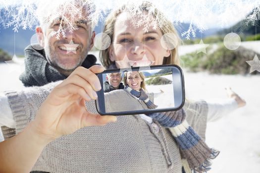 Hand holding smartphone showing photo against hanging decorations