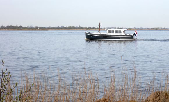 Small black yacht sailing in the Netherlands