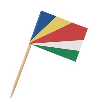 Small paper flag of Seychelles on wooden stick, isolated on white