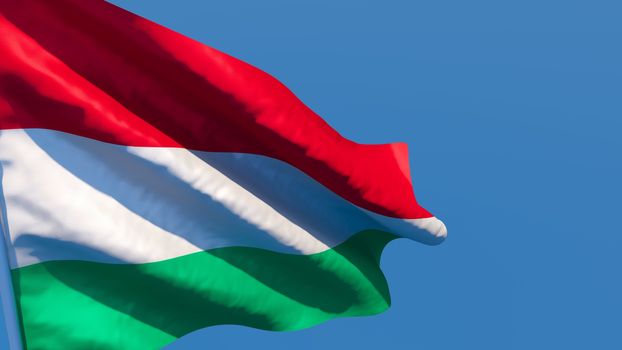 3D rendering of the national flag of Hungary waving in the wind against a blue sky.