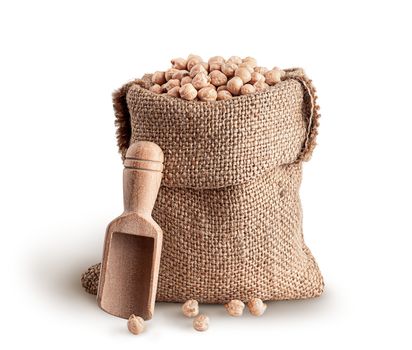 Sack with chickpeas and wooden scoop on white background