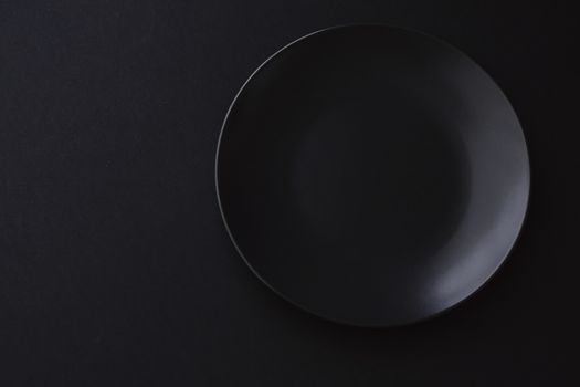 Empty plates on black background, premium dishware for holiday dinner, minimalistic design and diet concept