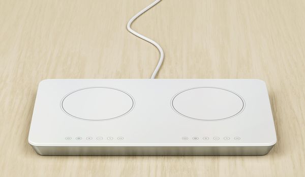 White induction cooktop on wood table