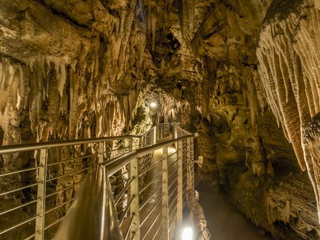 explores cave with stalagmites and stalactites