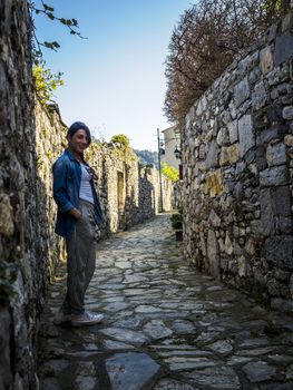 beautiful girl wolking in the National park of Cinque Terre in Liguria, Italy, looking through the lens.