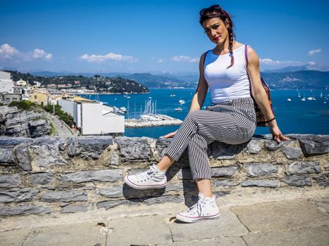 beautiful girl in the National park of Cinque Terre in Liguria, Italy, looking through the lens.