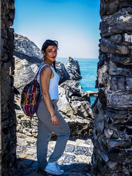 beautiful girl in the National park of Cinque Terre in Liguria, Italy, looking through the lens.