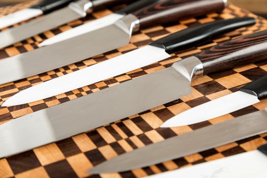 A set of high quality kitchen knives on a wooden cutting board