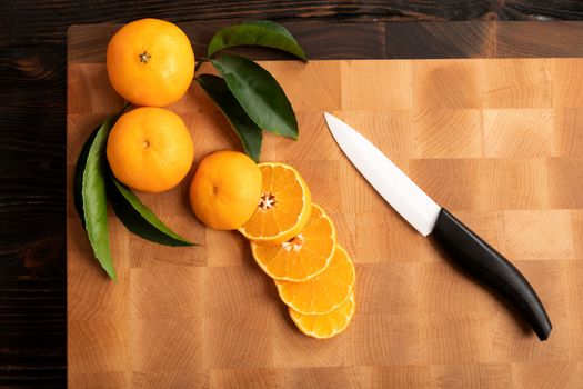 Still life with fruit. Sliced orange and other fruits on a wooden cutting board