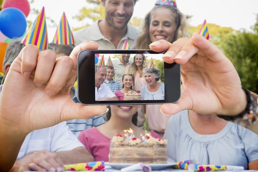 Composite image of hand holding smartphone showing photograph