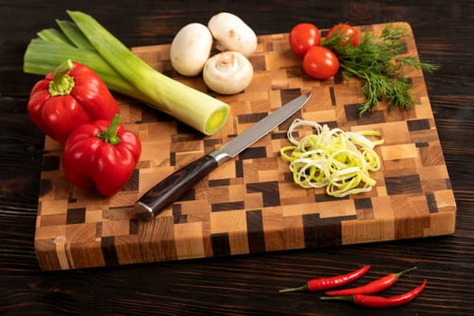 Knife vegetables and spices on a wooden cutting board