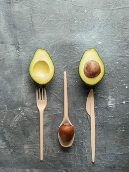 Avocado Seeds Biodegradable Single-Use Cutlery. Bioplastic - Great alternative to plastic disposable cutlery. Top view, flat lay. Copy space for text or design. Gray background. Vertical