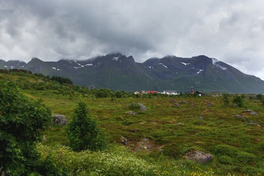Typical scandinavian landscape with meadows, mountains and village. Lofoten islands, Norway.