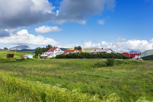 Typical scandinavian landscape with meadows, mountains and village. Lofoten islands, Norway.