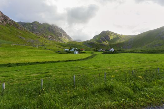 Beautiful scandinavian landscape with meadows, mountains and village. Lofoten islands, Norway.
