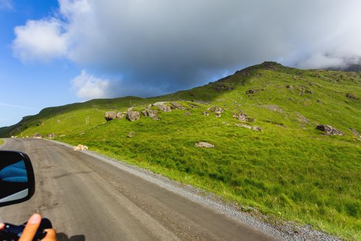 Beautifull scandinavian landscape with meadows and mountains. Sheep graze by themselves next to the road. Lofoten islands, Norway.