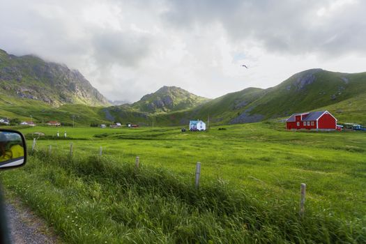 Typical scandinavian landscape with meadows, mountains and village. Lofoten islands, Norway.