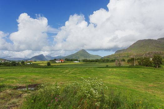 Typical scandinavian landscape with meadows, mountains and village. Lofoten islands, Norway.