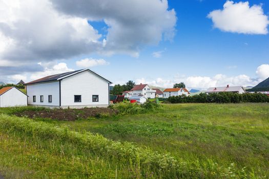 Typical scandinavian landscape with meadows, agricultural fields and village. Lofoten islands, Norway.