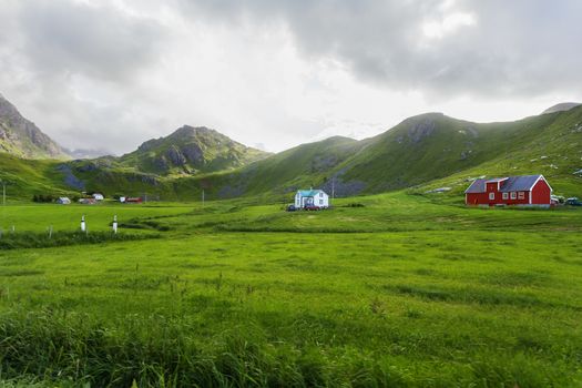 Beautiful scandinavian landscape with meadows, mountains and village. Lofoten islands, Norway.