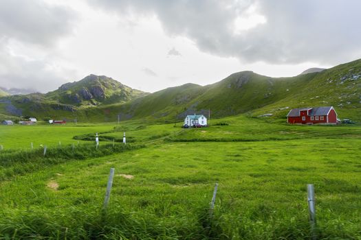 Beautiful scandinavian landscape with meadows, mountains and village. Lofoten islands, Norway.