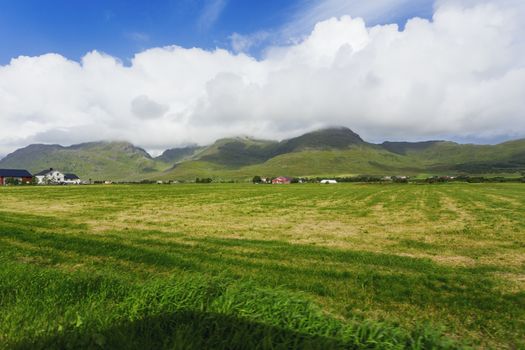 Typical scandinavian landscape with meadows, mountains and village. Lofoten islands, Norway.