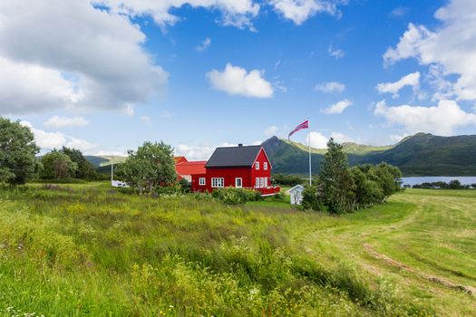 Typical scandinavian landscape with meadows, mountains and village. Lofoten islands, Norway.