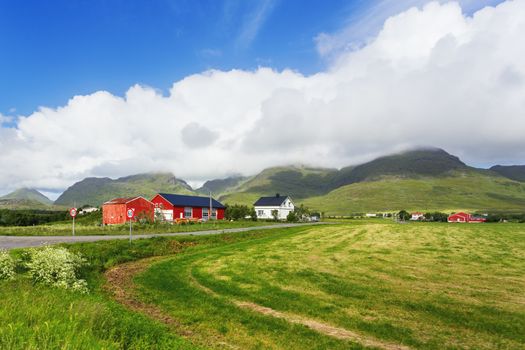 Typical scandinavian landscape with meadows, mountains and village. Lofoten islands, Norway.
