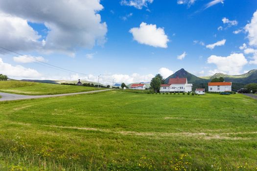 Typical scandinavian landscape with meadows, mountains and village. Lofoten islands, Norway.