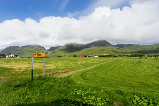 Typical scandinavian landscape with meadows, mountains and village. Rise, Lofoten islands, Norway.