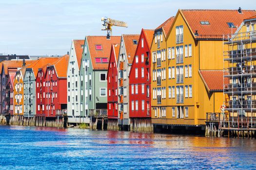 Famous wooden colored houses in Trondheim city, Norway. Colorful houses on stilts in sunny day.