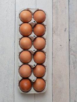 eggs in their box on white wooden background