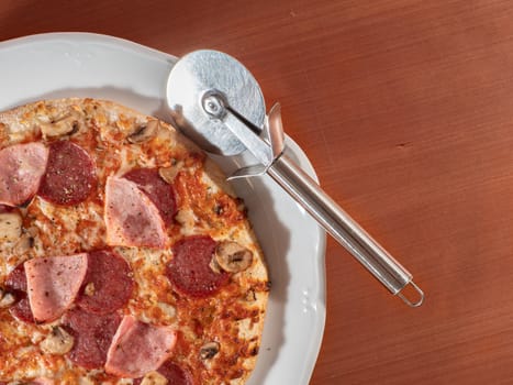 homemade pizza on white plate and wooden background overhead view