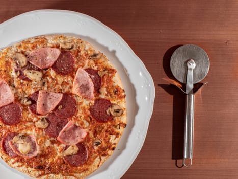 homemade pizza on white plate and wooden background overhead view