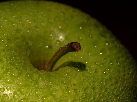 macro detail of a green apple with water drops