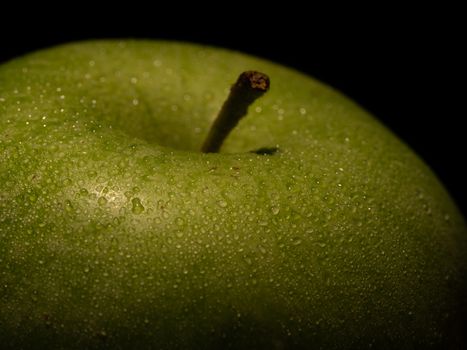 macro detail of a green apple with water drops