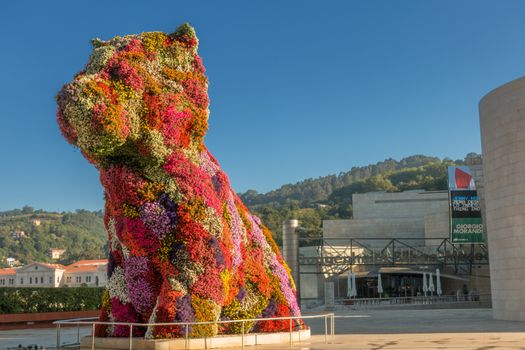 statue of a giant dog covered by flowers